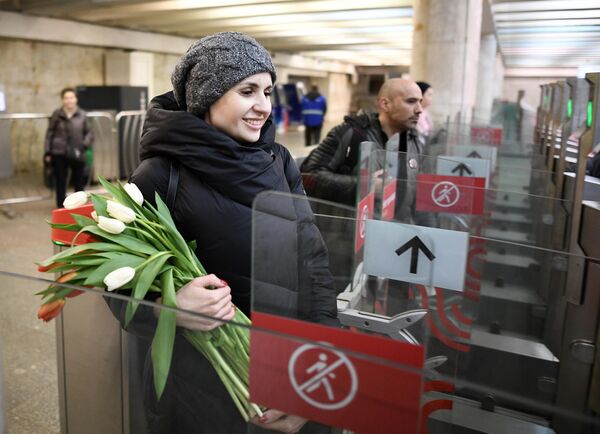 Девушка проходит через турникет в метрополитене Девушка проходит через турникет в метрополитене