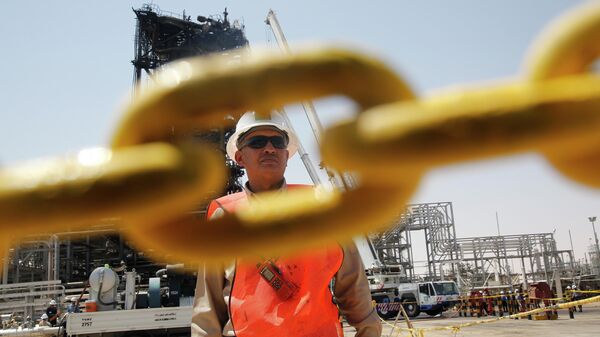 Рабочий на нефтяном месторождении в Саудовской Аравии Рабочий на нефтяном месторождении в Саудовской Аравии