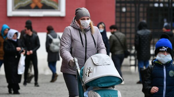 Прохожие в защитных масках на Красной площади в Москве Прохожие в защитных масках на Красной площади в Москве
