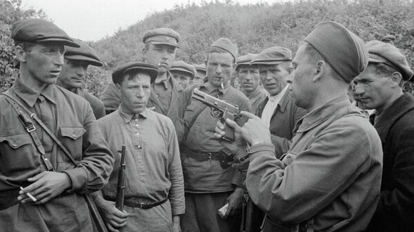 Командир партизанского отряда знакомит бойцов с оружием. Смоленская область, Россия Командир партизанского отряда знакомит бойцов с оружием. Смоленская область, Россия