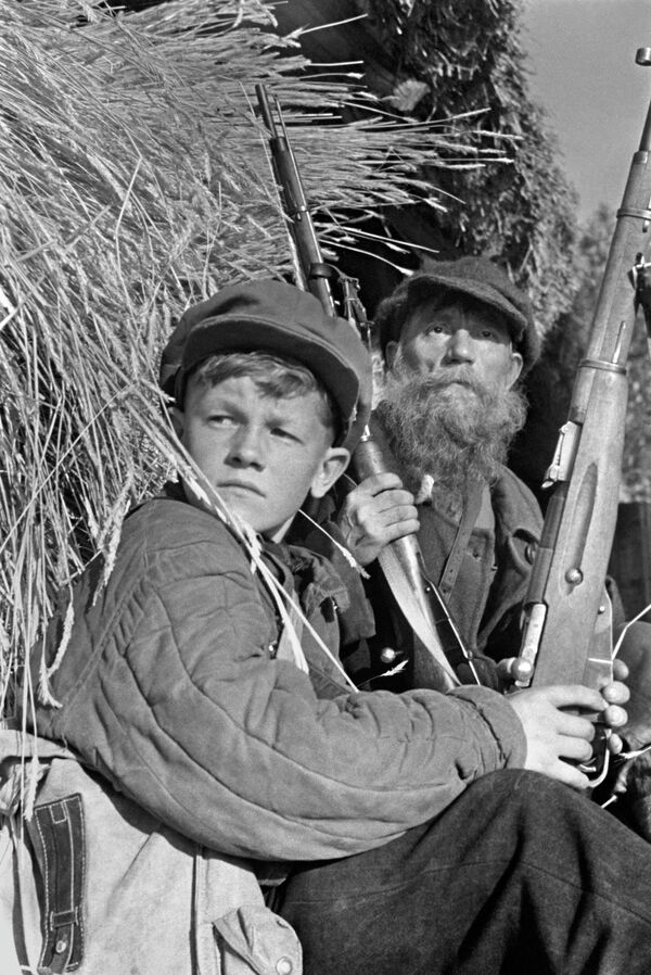 Партизаны в дозоре. 13-летний Леня Федоров и колхозник колхоза Борец И.В.Гришин, вступивший в партизанский отряд, несмотря на преклонный возраст Партизаны в дозоре. 13-летний Леня Федоров и колхозник колхоза Борец И.В.Гришин, вступивший в партизанский отряд, несмотря на преклонный возраст