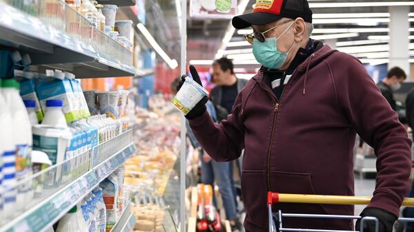 Мужчина в защитной маске покупает продукты в гипермаркете Мужчина в защитной маске покупает продукты в гипермаркете