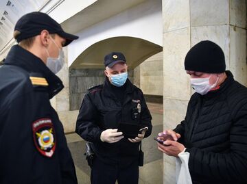 Сотрудники полиции в защитных масках на станции метро Москвы Охотный ряд проверяют цифровой пропуск у пассажира Сотрудники полиции в защитных масках на станции метро Москвы Охотный ряд проверяют цифровой пропуск у пассажира