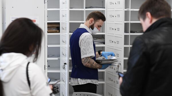 Сотрудник раскладывает корреспонденцию в отделении Почты России в Москве