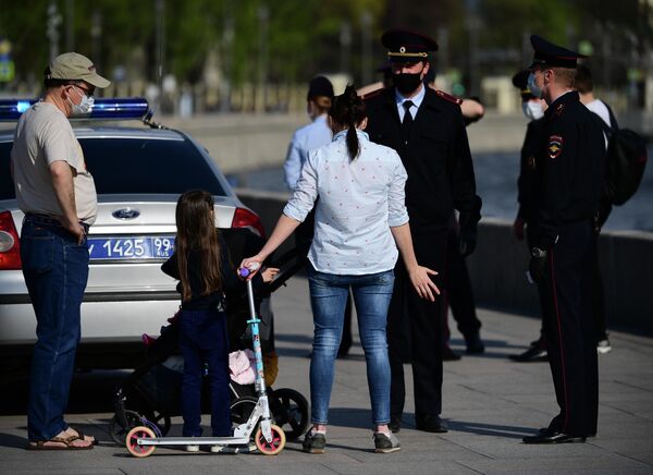 Сотрудники полиции проверяют документы у жителей, гуляющих на Москворецкой набережной в Москве Сотрудники полиции проверяют документы у жителей, гуляющих на Москворецкой набережной в Москве