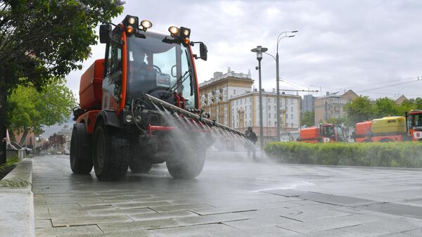 Автомобиль коммунальных служб во время дезинфекции тротуаров в Москве Автомобиль коммунальных служб во время дезинфекции тротуаров в Москве