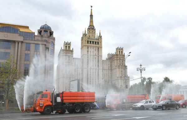 Автомобили коммунальных служб во время дезинфекции проезжей части дорог в Москве Автомобили коммунальных служб во время дезинфекции проезжей части дорог в Москве