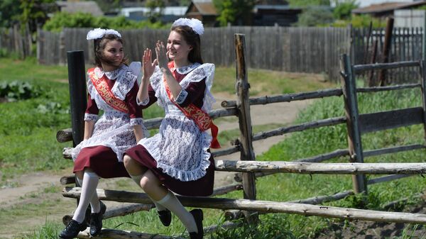 Выпускницы во время последнего звонка около сельской школы села Миасское Челябинской области Выпускницы во время последнего звонка около сельской школы села Миасское Челябинской области