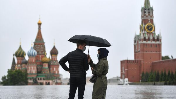 Прохожие во время дождя на Красной площади в Москве Прохожие во время дождя на Красной площади в Москве