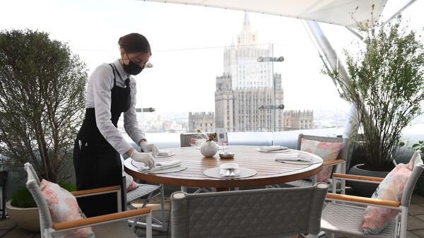 Официантка в защитной маске на открывшейся летней веранде ресторана Сахалин в Москве