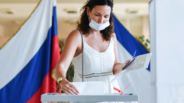 Женщина принимает участие в голосовании по внесению поправок в Конституцию РФ на одном из избирательных участков в Симферополе Женщина принимает участие в голосовании по внесению поправок в Конституцию РФ на одном из избирательных участков в Симферополе