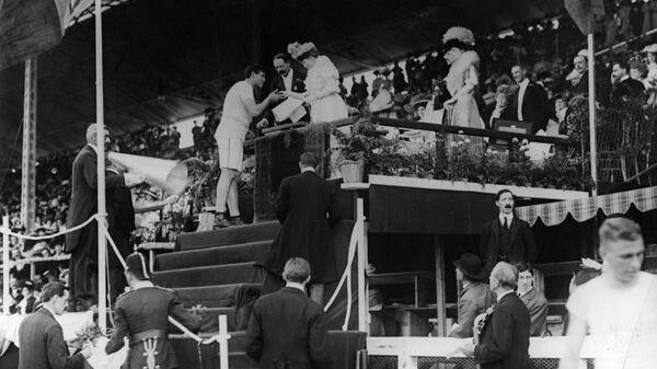 Королева Великобритании Александра вручает золотую медаль американскому легкоатлету Ральфу Роузу на Олимпийских играх 1908 года в Лондоне