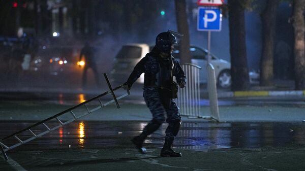 Сотрудник правоохранительных органов во время акции протеста в Бишкеке. Протестующие требуют аннулировать итоги парламентских выборов Сотрудник правоохранительных органов во время акции протеста в Бишкеке. Протестующие требуют аннулировать итоги парламентских выборов