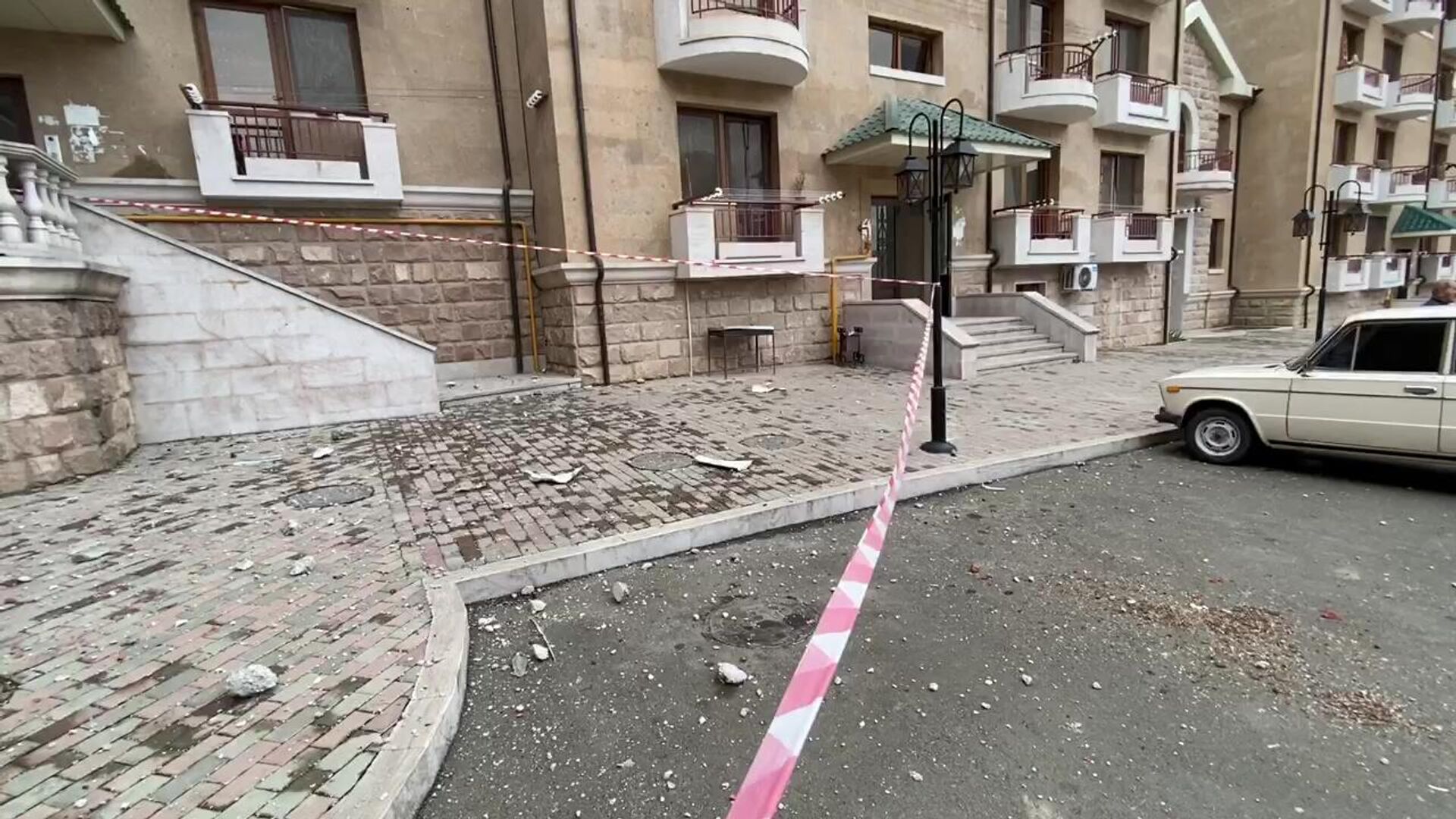 Обломки кирпича и бетона у жилого дома в центре Степанакерта, в балкон которого попала ракета системы залпового огня Смерч. Скриншот видео Обломки кирпича и бетона у жилого дома в центре Степанакерта, в балкон которого попала ракета системы залпового огня Смерч. Скриншот видео - РИА Новости, 1920, 08.10.2020