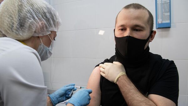 Медработник вводит вакцину в прививочном пункте по вакцинации от COVID-19 Медработник вводит вакцину в прививочном пункте по вакцинации от COVID-19
