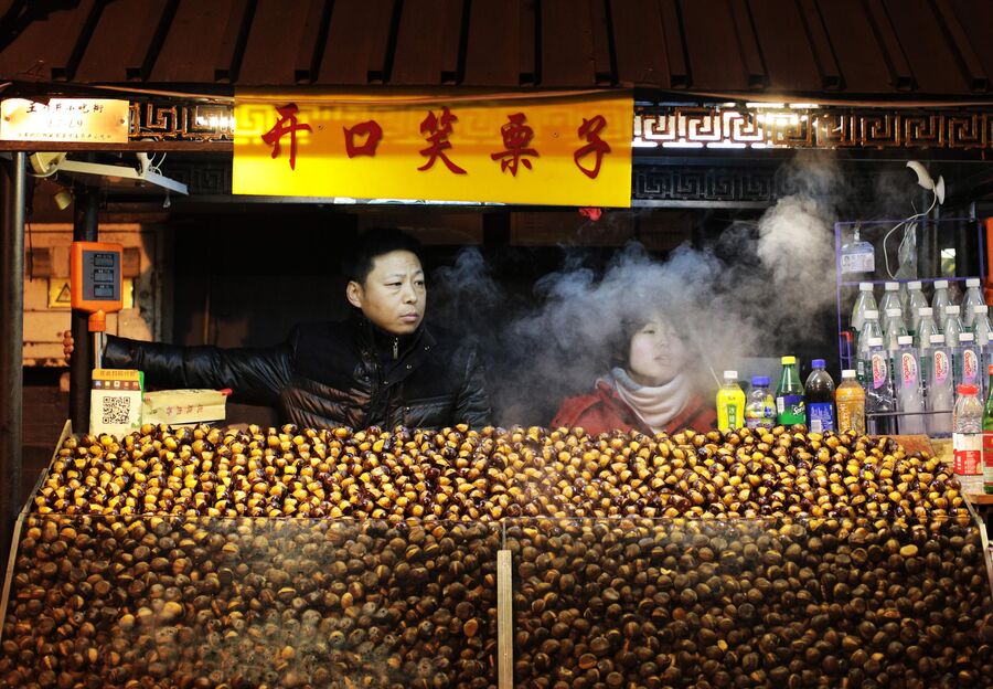 Посетители на рынке уличной еды Ванфуцзин в Пекине