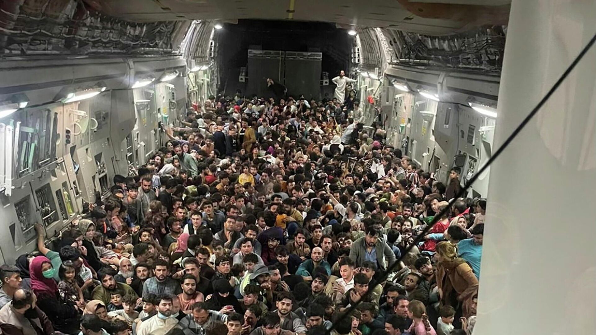Люди внутри транспортного самолета C-17 Globemaster III ВВС США, перевозящего около 640 афганцев в Катар из Кабула, Афганистан, 15 августа 2021 - РИА Новости, 1920, 18.08.2021