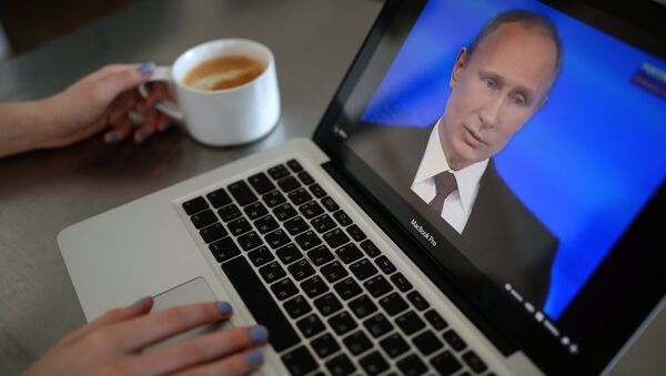 Жительница Новосибирска смотрит трансляцию ежегодной программы Прямая линия с Владимиром Путиным на экране ноутбука Жительница Новосибирска смотрит трансляцию ежегодной программы Прямая линия с Владимиром Путиным на экране ноутбука