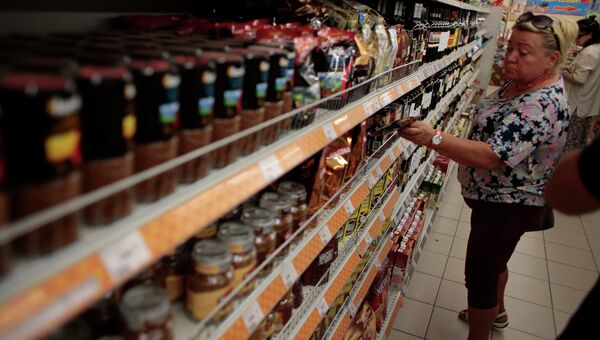 Женщина возле прилавка в одном из супермаркетов в Москве. Архивное фото Женщина возле прилавка в одном из супермаркетов в Москве. Архивное фото