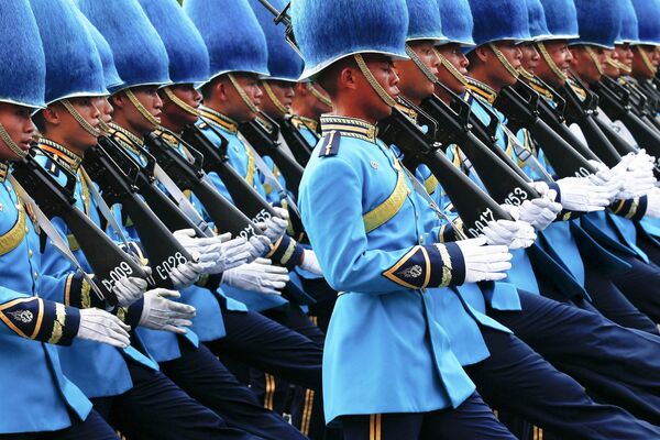 Тайская королевская гвардия марширует во время военного парада в честь празднования деня рождения короля Тайланда Пумипона Адульядета Тайская королевская гвардия марширует во время военного парада в честь празднования деня рождения короля Тайланда Пумипона Адульядета