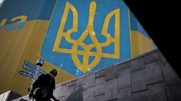 Женщина проходит мимо огромного украинского флага в центре Киева Женщина проходит мимо огромного украинского флага в центре Киева