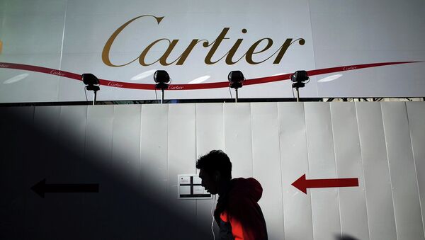 Прохожий на фоне рекламного баннера Cartier. Архивное фото Прохожий на фоне рекламного баннера Cartier. Архивное фото