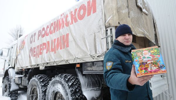 Сотрудник МЧС демонстрирует детский рождественский подарок во время формирования одиннадцатого гуманитарного конвоя для Донбасса Сотрудник МЧС демонстрирует детский рождественский подарок во время формирования одиннадцатого гуманитарного конвоя для Донбасса