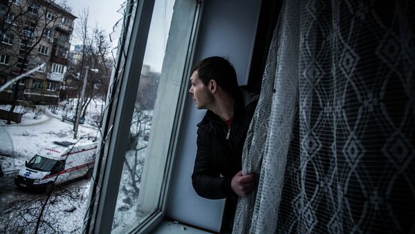 Мужчина смотрит через окно квартиры, поврежденной в результате артобстрела Донецка Мужчина смотрит через окно квартиры, поврежденной в результате артобстрела Донецка