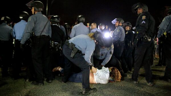 Полицейские задерживают участника акции протеста в Фергюсоне Полицейские задерживают участника акции протеста в Фергюсоне
