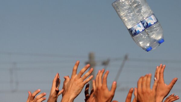 Мигранты ловят бутылки с водой на севере Греции недалеко от границы с Македонией Мигранты ловят бутылки с водой на севере Греции недалеко от границы с Македонией