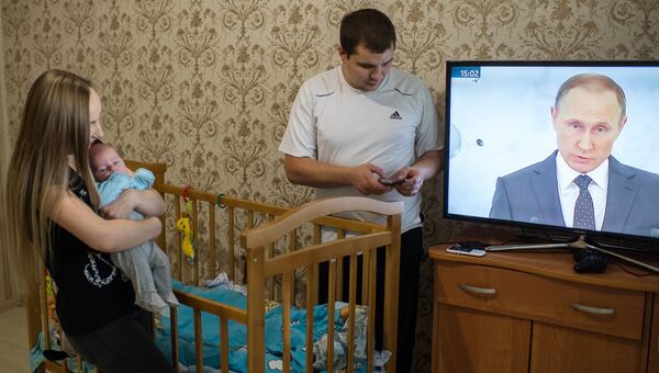 Молодая семья в Омске смотрит телевизионную трансляцию послания президента РФ Владимира Путина к Федеральному Собранию Молодая семья в Омске смотрит телевизионную трансляцию послания президента РФ Владимира Путина к Федеральному Собранию