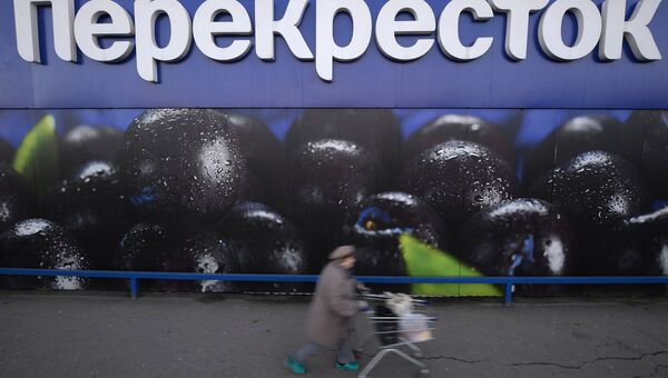 Женщина везет тележку с продуктами у супермаркета торговой сети Перекресток на Славянском бульваре в Москве Женщина везет тележку с продуктами у супермаркета торговой сети Перекресток на Славянском бульваре в Москве