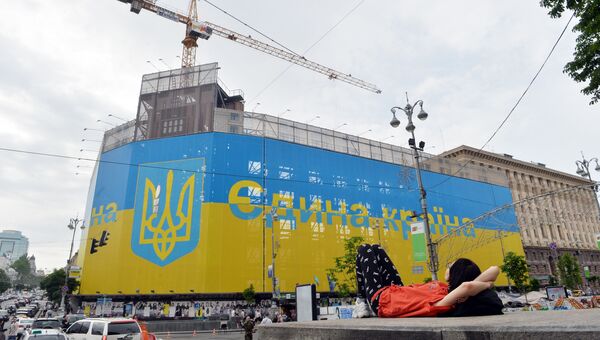 Флаг и герб Украины на здании в центре Киева. Архивное фото Флаг и герб Украины на здании в центре Киева. Архивное фото