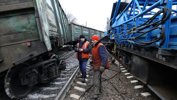 Рабочие осматривают поврежденный товарный вагон в районе станции Ясиноватая в Донецкой области, где в результате подрыва электровоза сошли с рельсов семь вагонов. 17 февраля 2016 Рабочие осматривают поврежденный товарный вагон в районе станции Ясиноватая в Донецкой области, где в результате подрыва электровоза сошли с рельсов семь вагонов. 17 февраля 2016