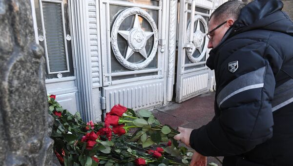 Мужчина возлагает цветы у здания министерства иностранных дел РФ в связи с гибелью посла России в Турции Андрея Карлова Мужчина возлагает цветы у здания министерства иностранных дел РФ в связи с гибелью посла России в Турции Андрея Карлова