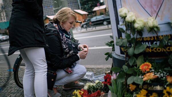 Девушка зажигает свечу недалеко от места теракта в Берлине. 20 декабря 2016 Девушка зажигает свечу недалеко от места теракта в Берлине. 20 декабря 2016