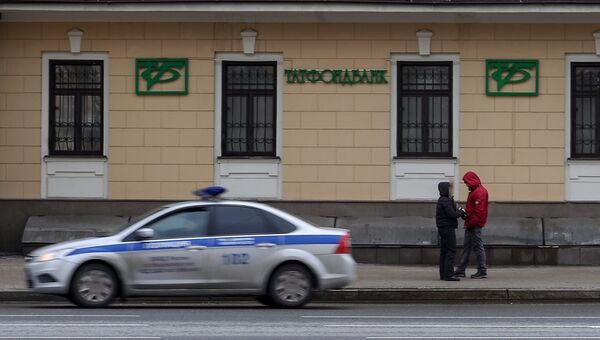 Автомобиль полиции едет мимо здания в Москве, в котором расположен офис Татфондбанка. Архивное фото Автомобиль полиции едет мимо здания в Москве, в котором расположен офис Татфондбанка. Архивное фото