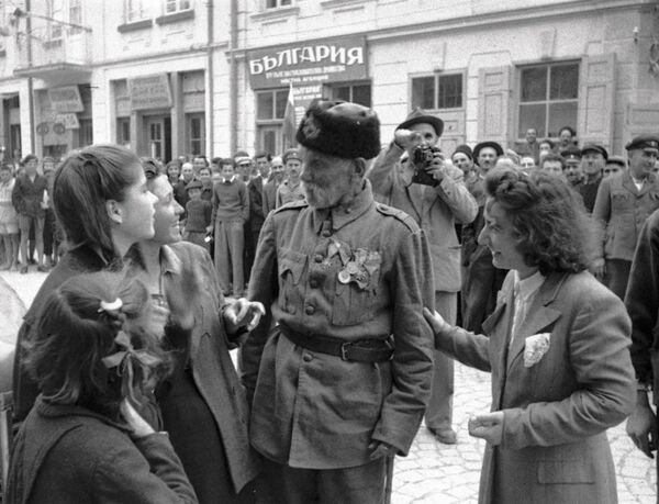 Ветеран турецкой войны беседует с девушками, в освобожденном войсками РККА от фашистов, болгарском городе Ветеран турецкой войны беседует с девушками, в освобожденном войсками РККА от фашистов, болгарском городе