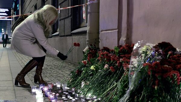 Женщина возлагает цветы рядом со станцией метро Технологический институт в память о погибших в результате взрыва в метро Санкт-Петербурга Женщина возлагает цветы рядом со станцией метро Технологический институт в память о погибших в результате взрыва в метро Санкт-Петербурга