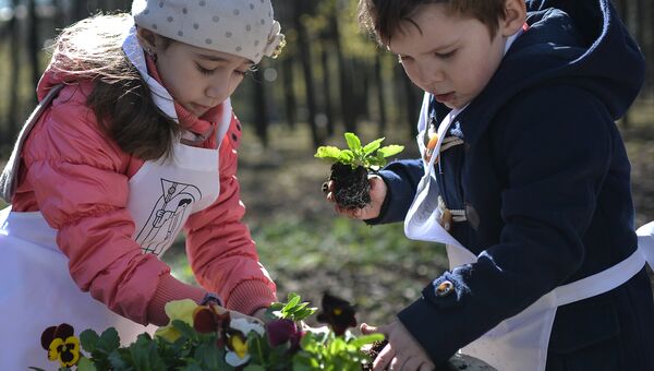 Дети высаживают цветы в клумбы в Нескучном Саду во время общегородского субботника Дети высаживают цветы в клумбы в Нескучном Саду во время общегородского субботника