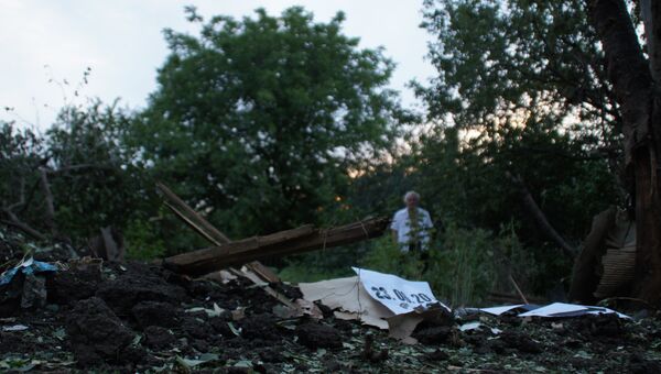 Местный житель стоит у воронки от снаряда во дворе соседского дома в Кировске, ЛНР. 23 июня 2017 Местный житель стоит у воронки от снаряда во дворе соседского дома в Кировске, ЛНР. 23 июня 2017