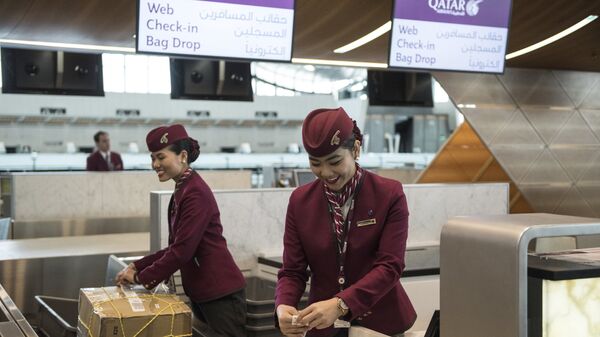Сотрудницы авиакомпании Qatar Airways оформляют багаж пассажиров в Международном аэропорте Хамад в Дохе Сотрудницы авиакомпании Qatar Airways оформляют багаж пассажиров в Международном аэропорте Хамад в Дохе