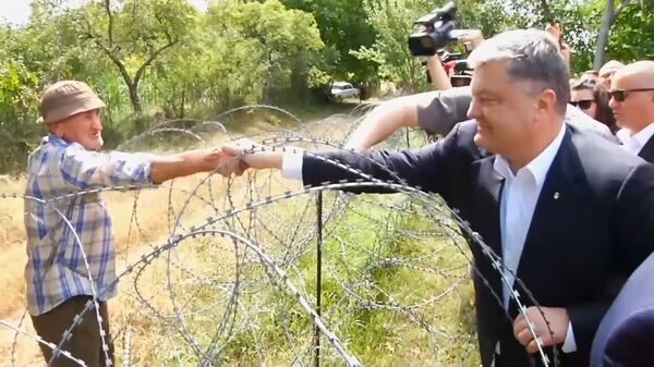 Порошенко в Грузии через границу поздоровался за руку с жителем Южной Осетии Порошенко в Грузии через границу поздоровался за руку с жителем Южной Осетии