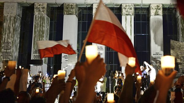 Свечи в руках антиправительственных демонстрантов напротив здания Верховного суда в Варшаве, Польша. 22 июля 2017 Свечи в руках антиправительственных демонстрантов напротив здания Верховного суда в Варшаве, Польша. 22 июля 2017