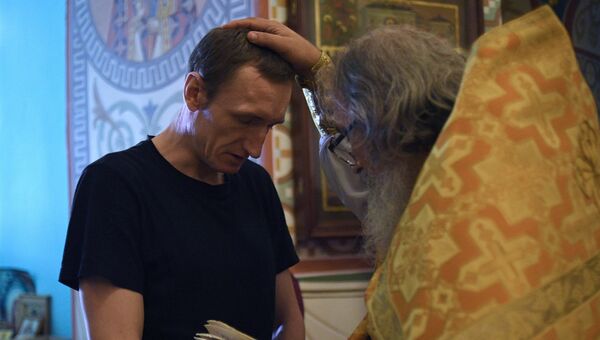 Священнослужитель и верующий во время Крещальной литургии и молебна о совершении правосудия в церкви Покрова Пресвятой Богородицы Бутырского замка. Архивное фотос Священнослужитель и верующий во время Крещальной литургии и молебна о совершении правосудия в церкви Покрова Пресвятой Богородицы Бутырского замка. Архивное фотос