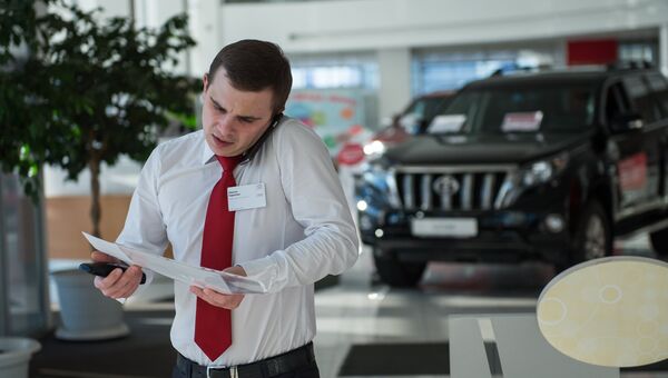 Менеджер по продажам в автосалоне. Архивное фото Менеджер по продажам в автосалоне. Архивное фото