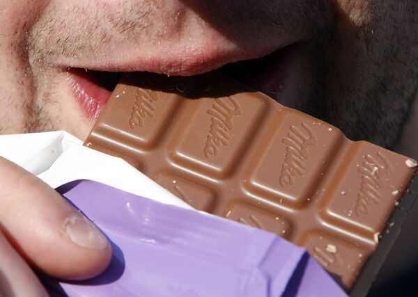 Мужчина ест шоколад Milka Мужчина ест шоколад Milka