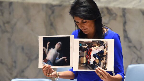 Постпред США при ООН Никки Хейли держит фотографии жертв предполагаемой химической атаки в Сирии Постпред США при ООН Никки Хейли держит фотографии жертв предполагаемой химической атаки в Сирии