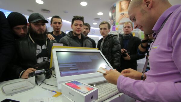Продавец за прилавком во время старта продаж нового смартфона iPhone X в магазине Связной на Тверской улице в Москве Продавец за прилавком во время старта продаж нового смартфона iPhone X в магазине Связной на Тверской улице в Москве