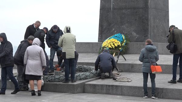 Рабочие ломами сбивали цемент с оскверненного Вечного огня в Киеве Рабочие ломами сбивали цемент с оскверненного Вечного огня в Киеве